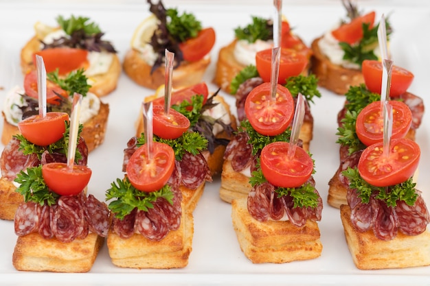 Foto primer plato grande con servir canapés snack pan frito tomate perejil y salami