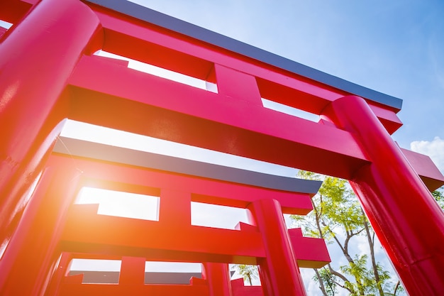 Primer de las puertas rojas de Torii con el fondo del cielo azul.