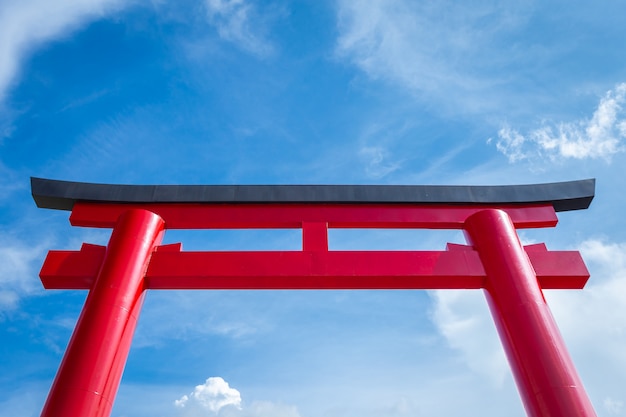 Primer de las puertas rojas de Torii con el fondo del cielo azul.