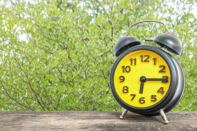 Primer reloj despertador a las seis y cuarto en el escritorio de madera