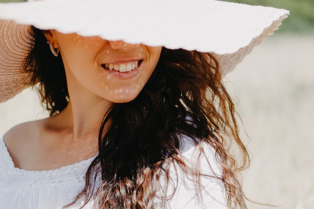 Foto el primer retrato de una mujer con un sombrero cerrado en el piso de la cara en el marco solo sonríe.