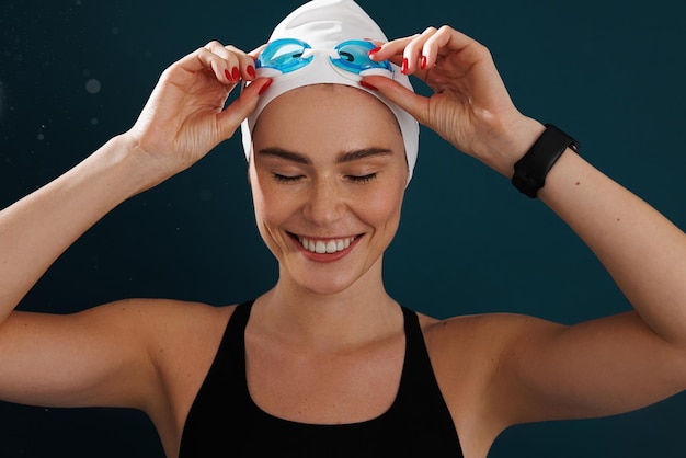 Primer retrato de una nadadora sonriente con gorro de baño y gafas