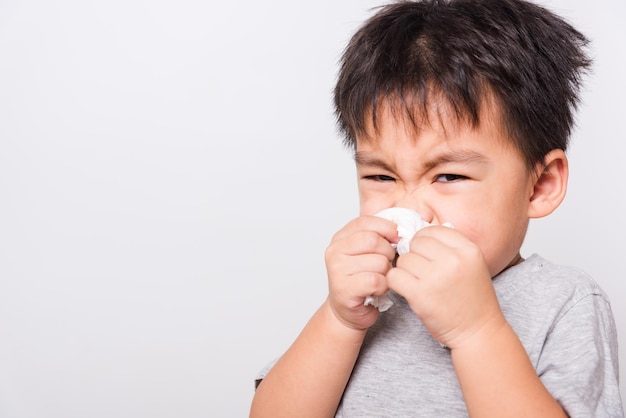 Primer rostro asiático Niños pequeños niño limpiando la nariz con un pañuelo