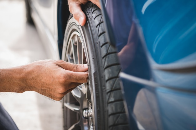 Primer técnico automotriz masculino que quita la tapa de nitrógeno de la válvula del neumático para inflar el neumático