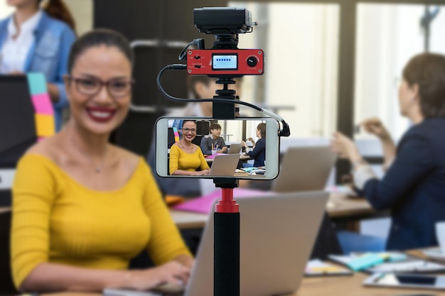 Foto primer teléfono móvil inteligente tomando en vivo de empresaria trabajando