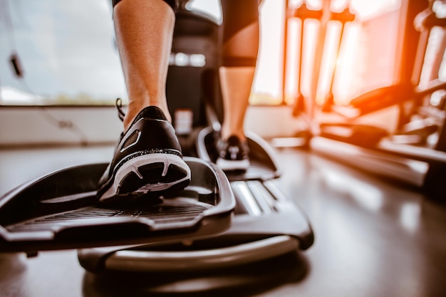 Primer tramo de entrenamiento cardiovascular en una elíptica.personas trabajando en una elíptica en el gimnasio.Vista posterior