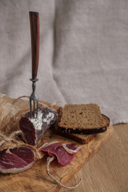 Primer trozo de jamón en tenedor luz aperitivo comida casera enfoque selectivo