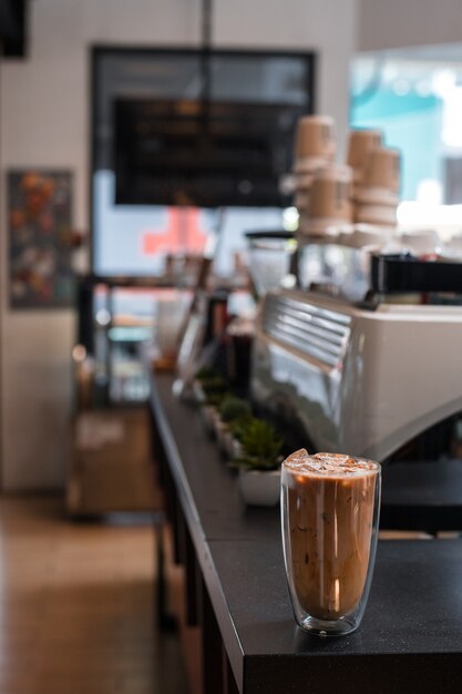 Primer vaso de café helado con leche sobre la mesa