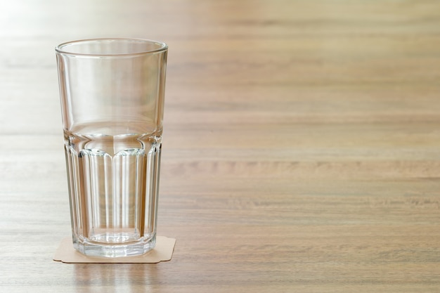 Foto primer vaso vacío en la mesa de madera, lo que significa una actitud positiva hacia algo y un impulso para aprender cualquier cosa