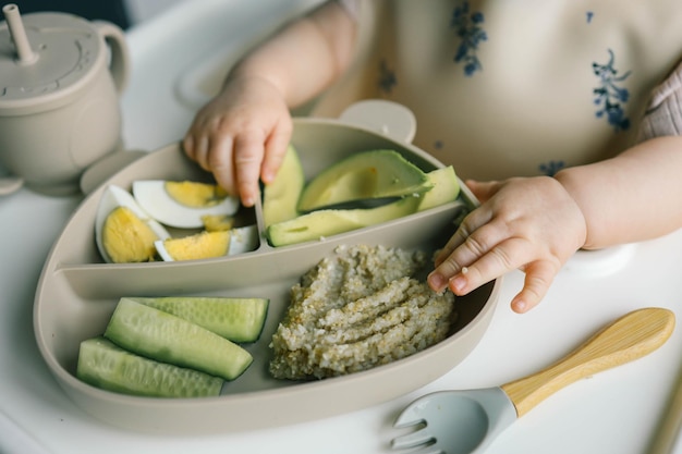 Primero soplar comida para bebés Pequeño bebé comiendo verduras orgánicas con el método BLW Infante comiendo alimentos saludables autosuficiente