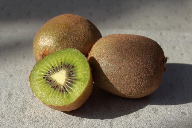 Primeros planos de kiwis, uno de los cuales está cortado por la mitad