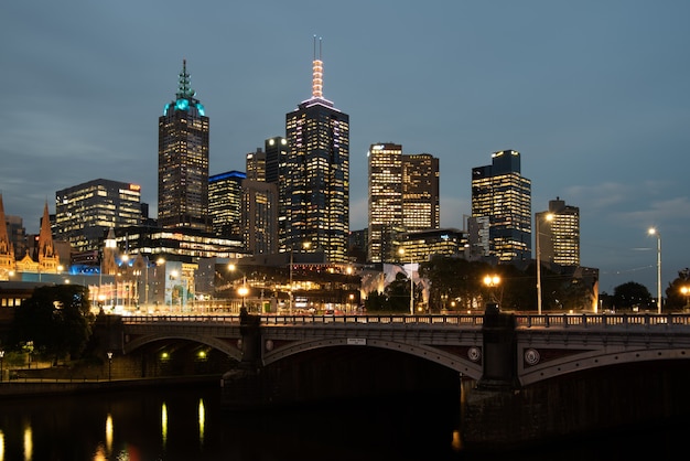 Foto princes bridge y edificios de la ciudad sobre el río yarra en melbourne, australia, en la noche