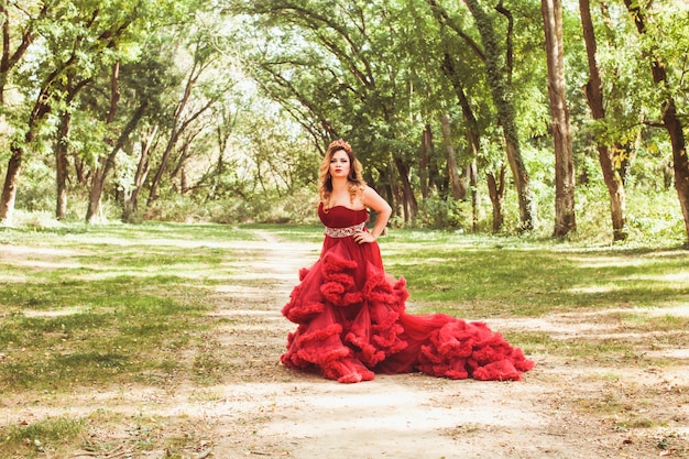 Princesa con corona en vestido rojo nublado