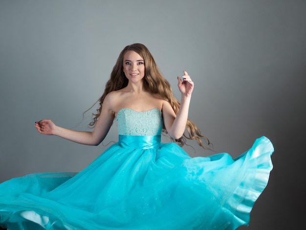 Foto princesa dançarina maravilhosa em um vestido azul exuberante, uma jovem loira linda