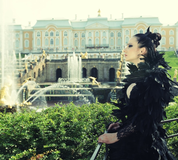 Princesa en el parque junto a la fuente y el palacio.