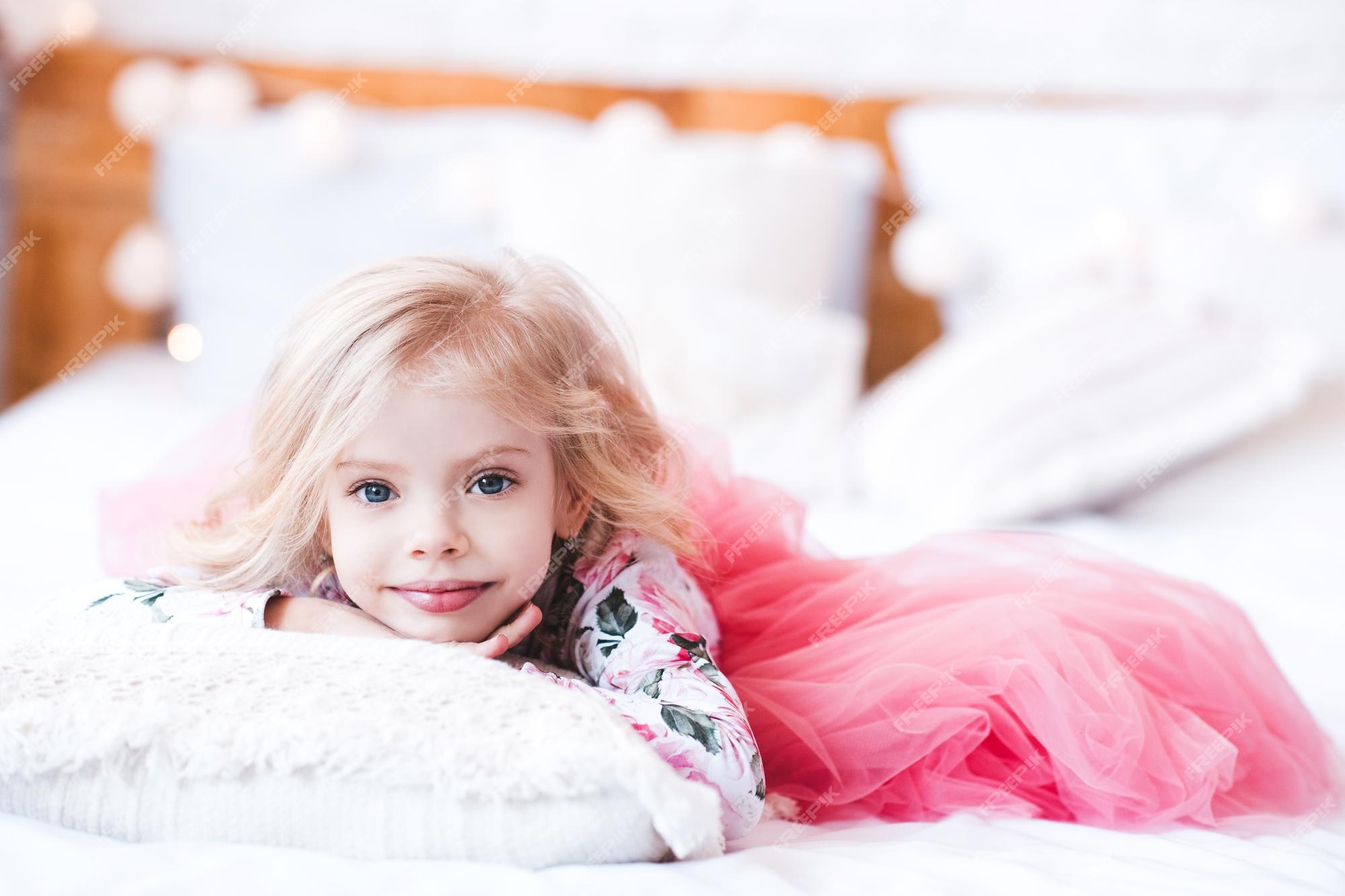 Princesinha com um vestido elegante e fofo deitada na cama