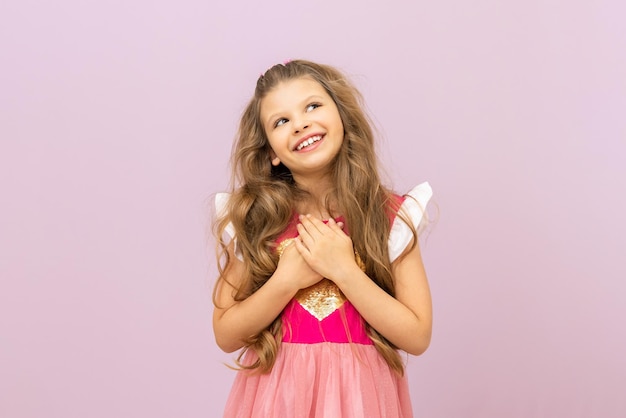 La princesita sueña con unas vacaciones solemnes. niños con cabello rizado sobre un fondo aislado.