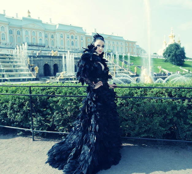 Prinzessin im Park neben Brunnen und Schloss