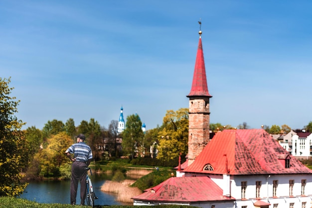 Priory Castle in Gatchina Blick vom See Russland Gatchina 2022 Ein Mann bewundert den Park