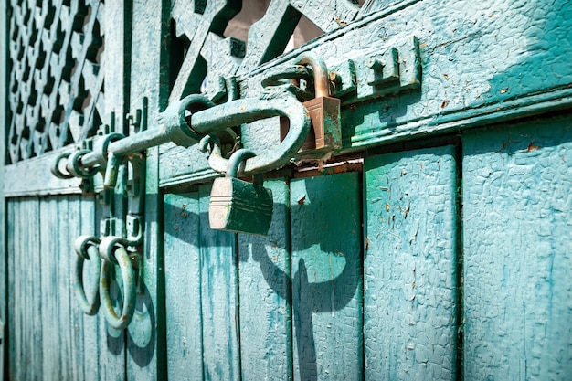 Prisão de ventre e fechaduras enferrujadas de portões trancados Antigo portão de igreja de madeira com tinta azul giz