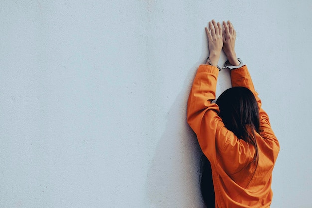 Prisionero en concepto de túnica naranja Retrato de mujer asiática en uniformes de prisión sobre fondo blanco