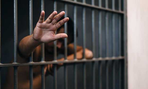 Prisionero mostrando la mano mientras está de pie en la cárcel