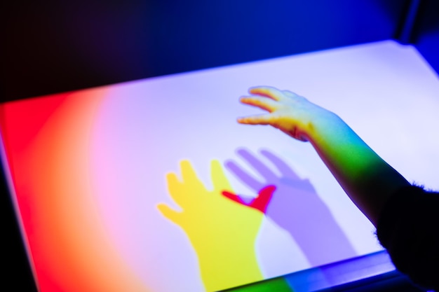 Prisma arco iris luz y sombra de una mano.