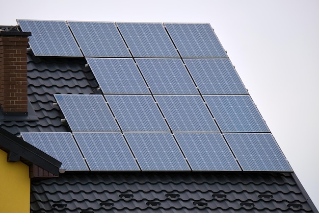 Privates Hausdach mit Solar-Photovoltaik-Paneelen zur Erzeugung sauberer ökologischer elektrischer Energie in ländlichen Vororten bedeckt Konzept des autonomen Hauses