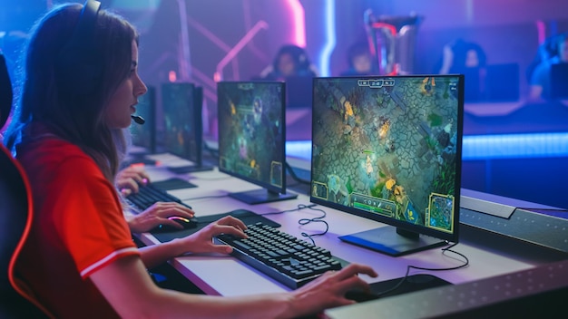 Pro Girl Juega Juego de Computadora Juega Estrategia RPG en un Campeonato Diverso Equipo de Esport de Jugadores Profesionales Juega en Mockup Videojuego Estilo Neon Cyber Juegos Arena Vista lateral
