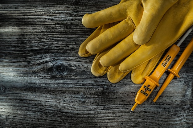 Probador eléctrico par de guantes de seguridad en tablero de madera