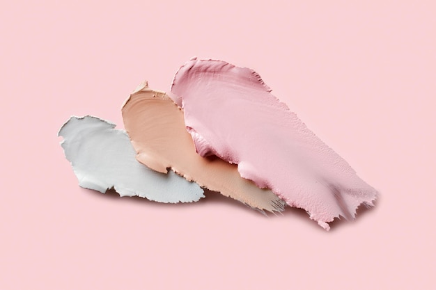 Proben von farbkorrigierenden Concealern Auf rosa Hintergrund gesetzt Swatch-Abstriche von Creme-Make-up-Basis