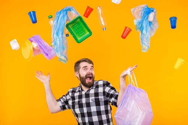 Problema de basura, reciclaje de plástico, contaminación y concepto ambiental - hombre divertido que lleva basura para reciclar