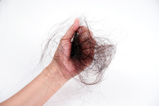 Problema de queda de cabelo nas mãos de mulheres isoladas no fundo branco