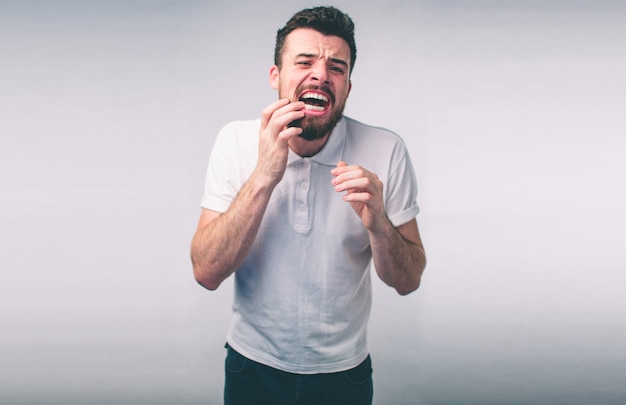 Problema de los dientes. El hombre siente dolor de dientes. Primer del muchacho barbudo que sufre de dolor de diente fuerte. Macho atractivo Sensación dolorosa dolor de muelas. Concepto de salud y cuidado dental