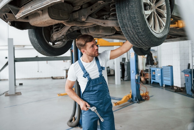 Problema incomum. Funcionário com uniforme azul trabalha no salão automóvel