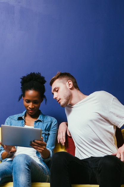 Foto problema de relación en pareja interracial, mujer ocupada con tableta ignora al hombre, ella hace negocios