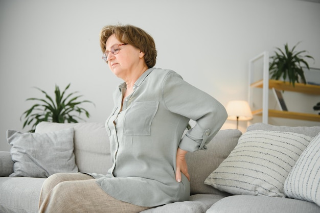 Problema de salud de la vejez y concepto de personas mujer mayor que sufre de dolor de espalda o riendas en casa