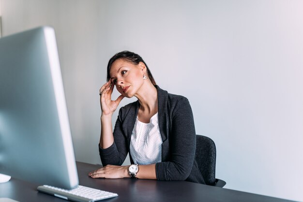 Problemas empresariales. Empresaria en cuestión que mira la pantalla.