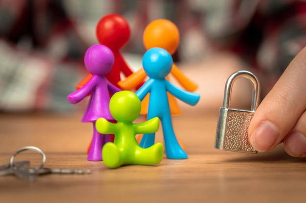 Problemas familiares figuritas de colores de plástico sobre una mesa de madera con candado Divorcio en familia con niños conflicto crisis concepto foto