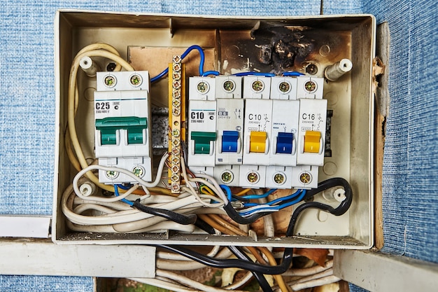 Problemas na chave de segurança, quadro elétrico antigo queimado e disjuntores localizados em prédio residencial.