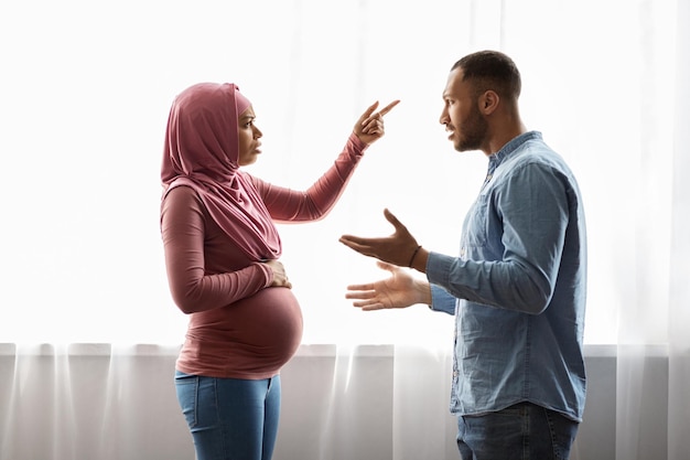 Problemas de relación durante el embarazo Pareja musulmana negra embarazada discutiendo en casa