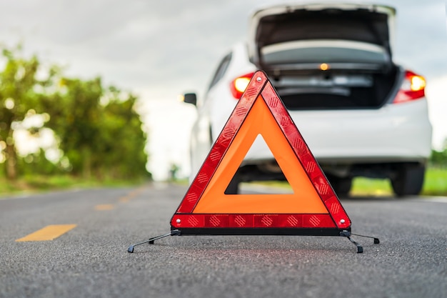 Problems car y un triángulo rojo señal de advertencia en la carretera