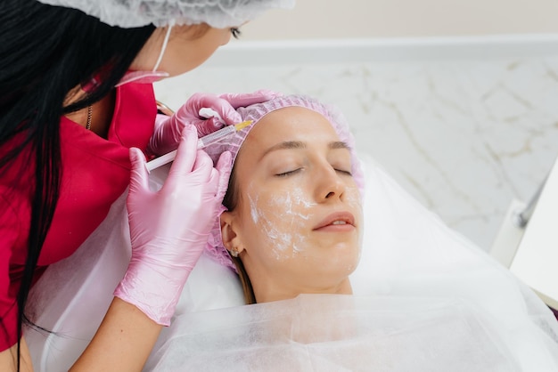 Procedimento cosmético para biorevitalização e remoção de rugas para uma linda jovem. Cosmetologia.