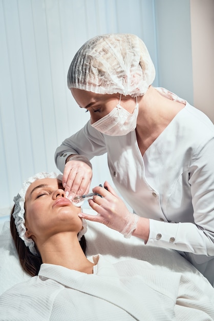 Procedimento de correção da forma dos lábios em um salão de cosmetologia