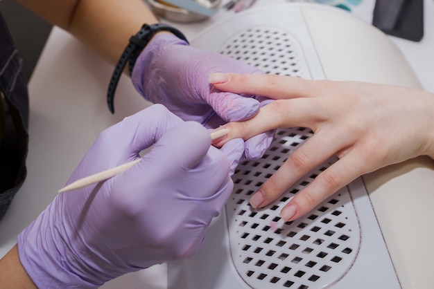 Procedimento de manicure usando uma vara de bambu em um salão de beleza.