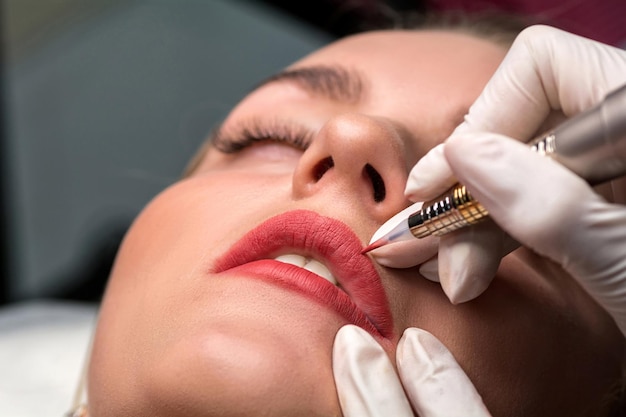 Procedimento de maquiagem permanente. maquiagem labial em salão de tatuagem.