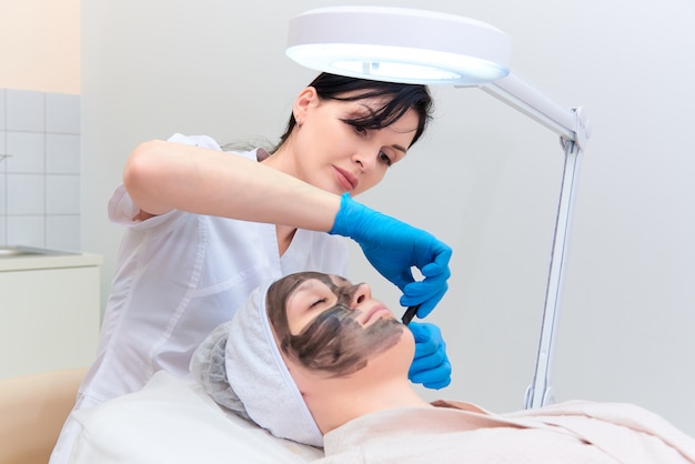 Procedimento de peeling facial com carbono na clínica de cosmetologia a laser.