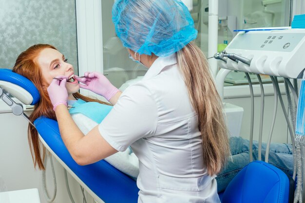 Foto procedimento de perfuração dentária e check-up em dentes bonitos e boca aberta.