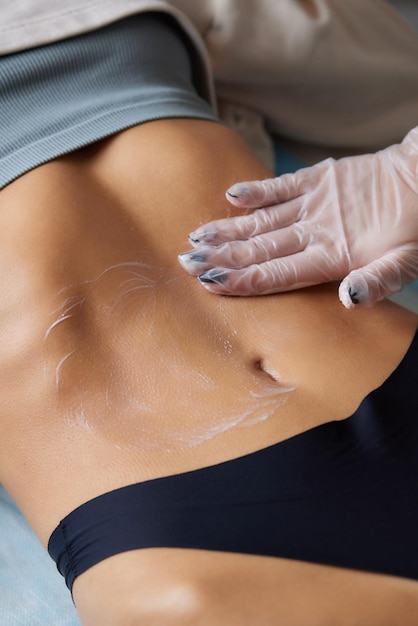 Foto procedimento de remoção de celulite no abdômen feminino cavitação massagem na barriga massagem ultrassônica para pesar