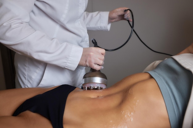 Procedimento de remoção de celulite no abdômen feminino cavitação massagem na barriga massagem ultrassônica para pesar